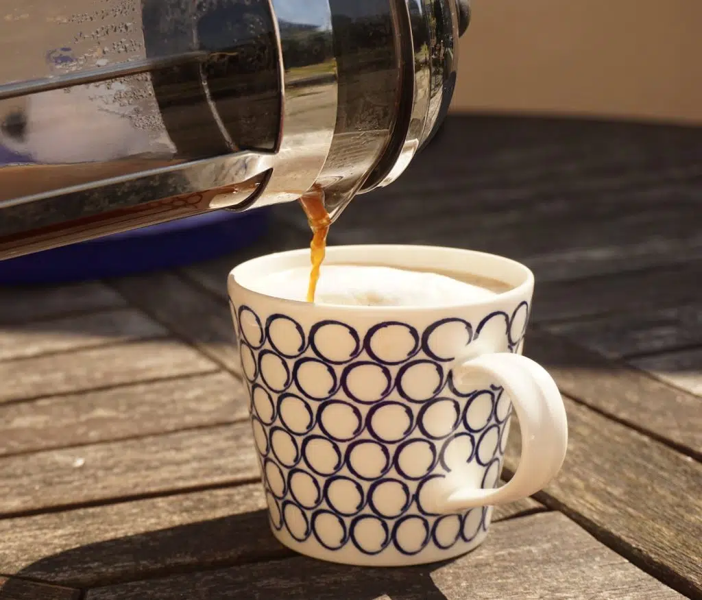 white and black ceramic mug on brown wooden table